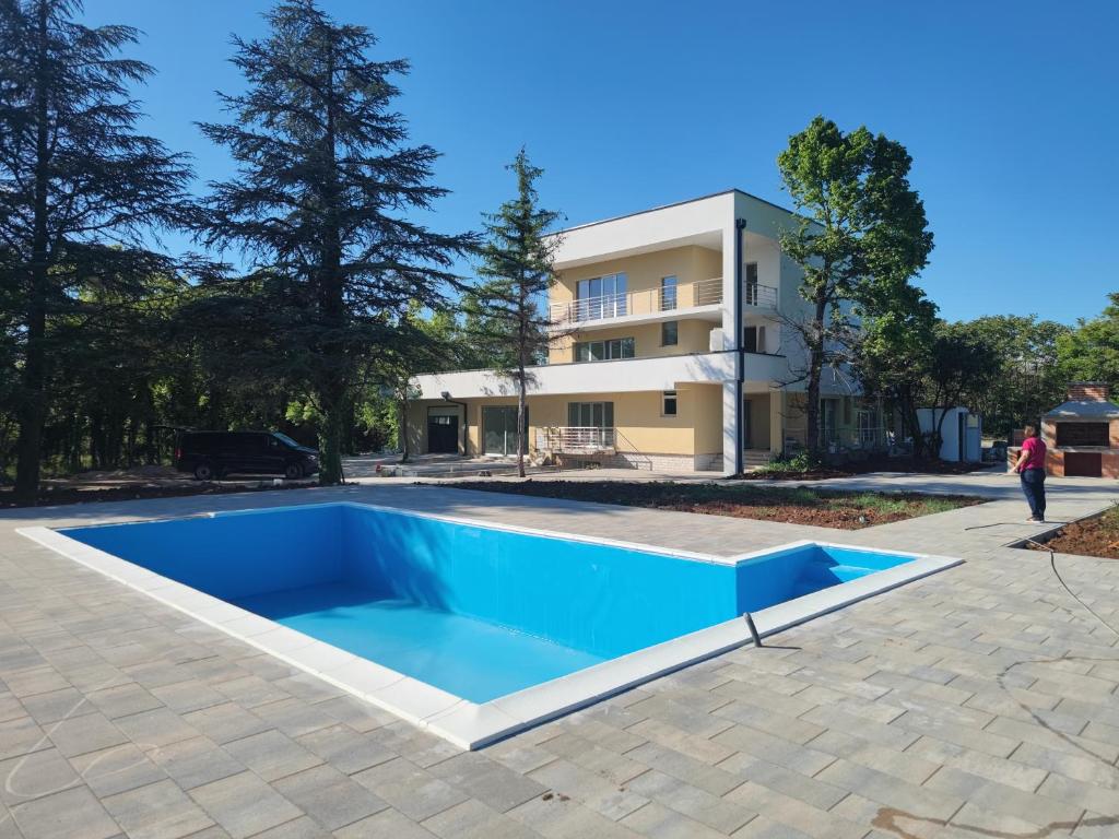 een zwembad voor een gebouw bij Villa Ella in Ljubuški