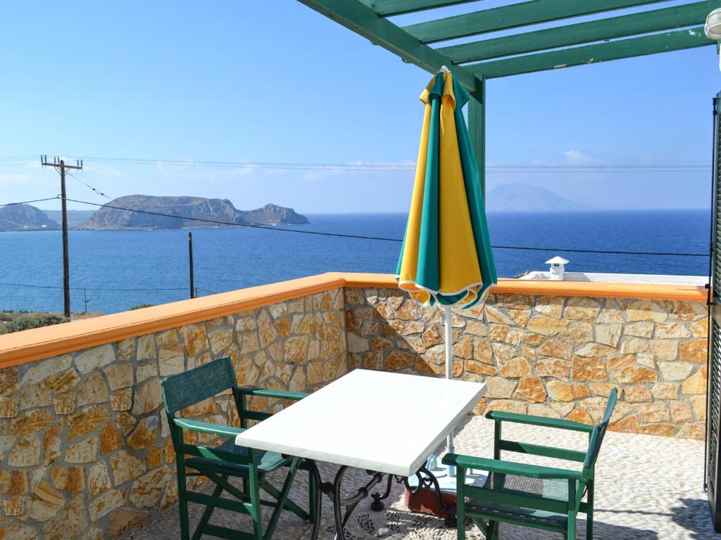 a table and two chairs and an umbrella on a balcony at Hotel Finiki View in Foiníkion