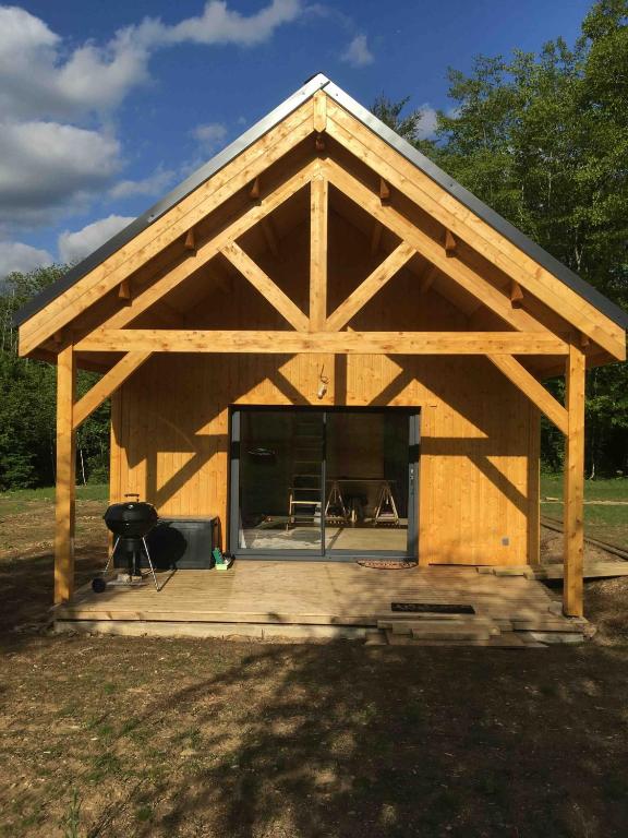 un grand hangar en bois avec une cheminée à l'intérieur dans l'établissement Cabane de Mardil, à Aubazines