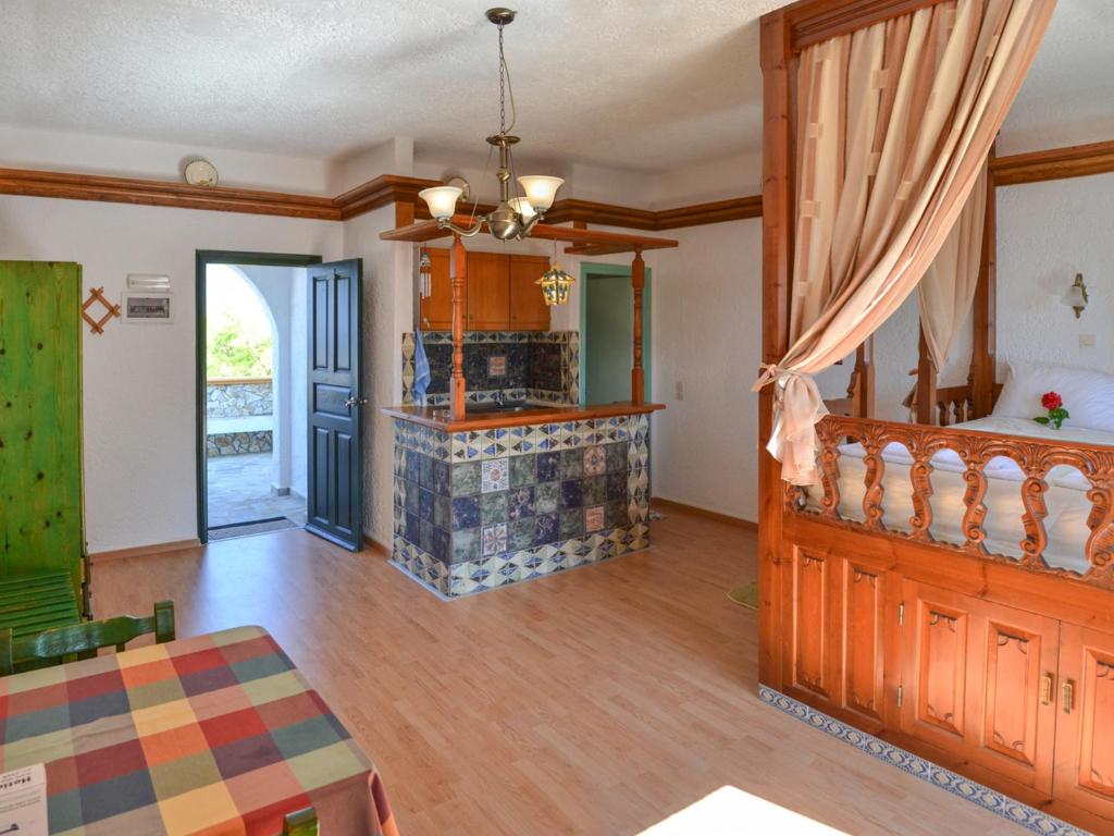 a living room with wooden floors and a dining room at Hotel Finiki View in Foiníkion