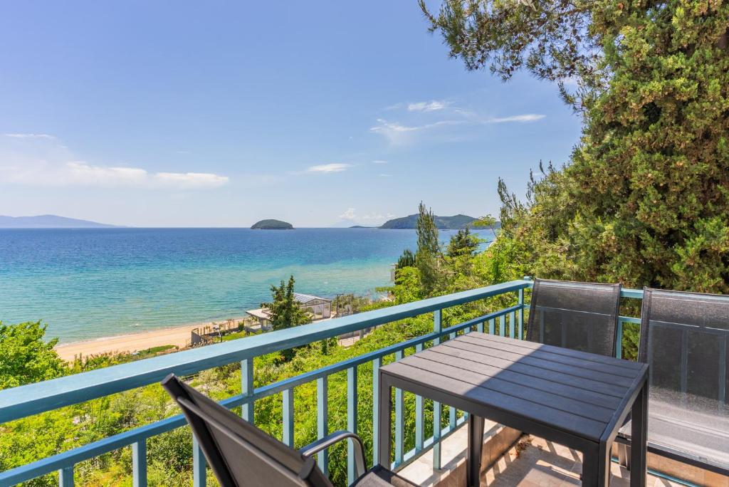 a table and chairs on a balcony overlooking the ocean at Balcony by the bay in Paleo Tsifliki