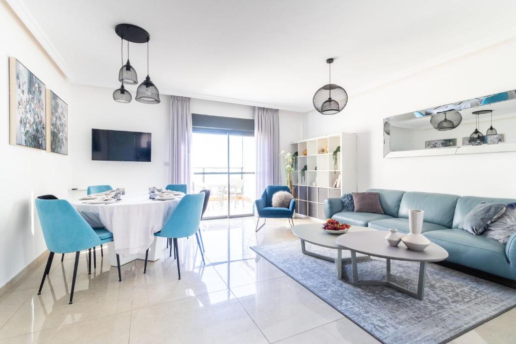sala de estar con sofá azul y mesa en Luxury 4 Bedroom With Amazing View In Ramat Sharet Bayt Vegan en Jerusalén