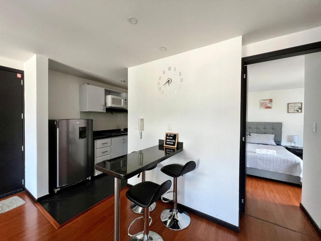 a kitchen with a table and two stools in a room at Apto completo Atures la mejor vista y ubicación! in Pasto