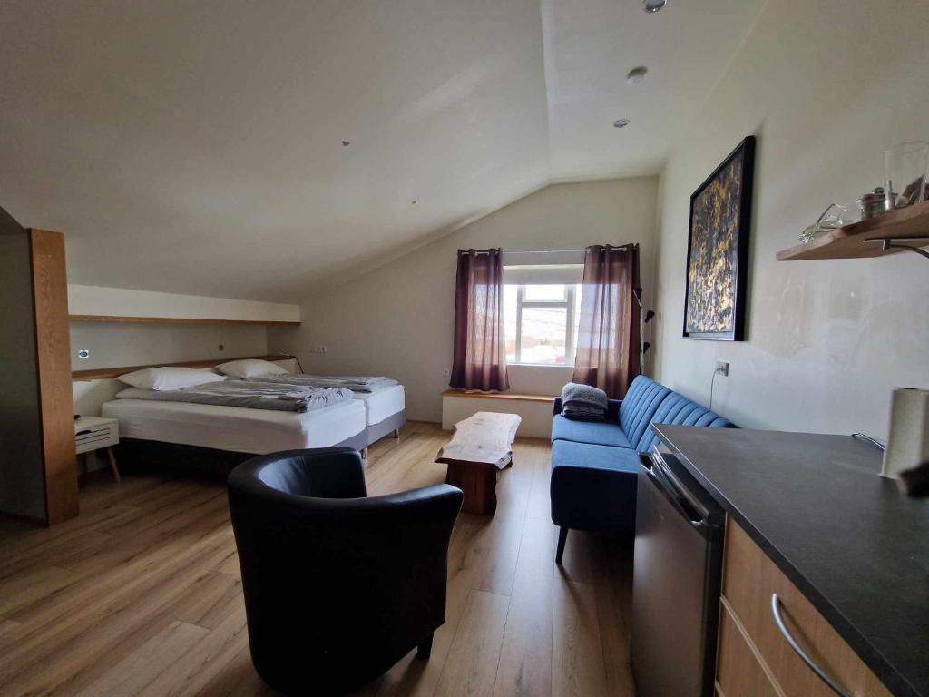 een hotelkamer met een bed en een blauwe bank bij Svansholl Apartments in Kaldrananes