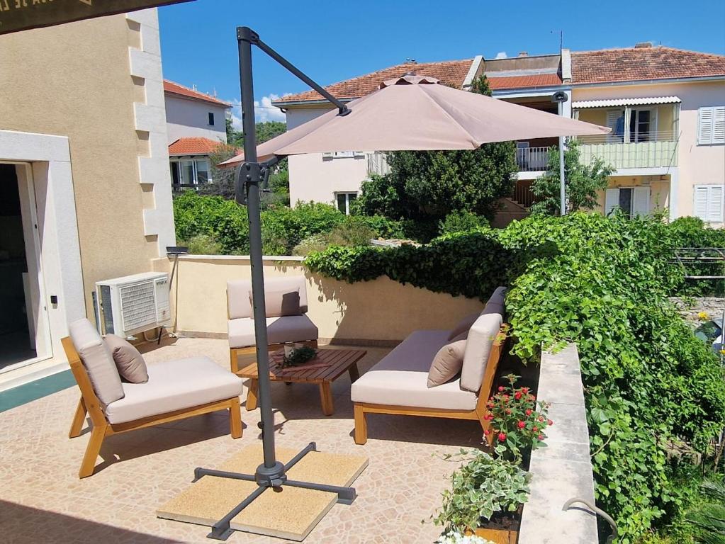 a patio with two chairs and an umbrella at Apartment GoodMood in Split
