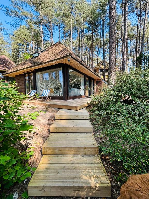 une maison avec un chemin en bois menant à une maison dans l'établissement 800m mer- La maison sous les pins-rénovée 2024, à Neufchâtel-Hardelot