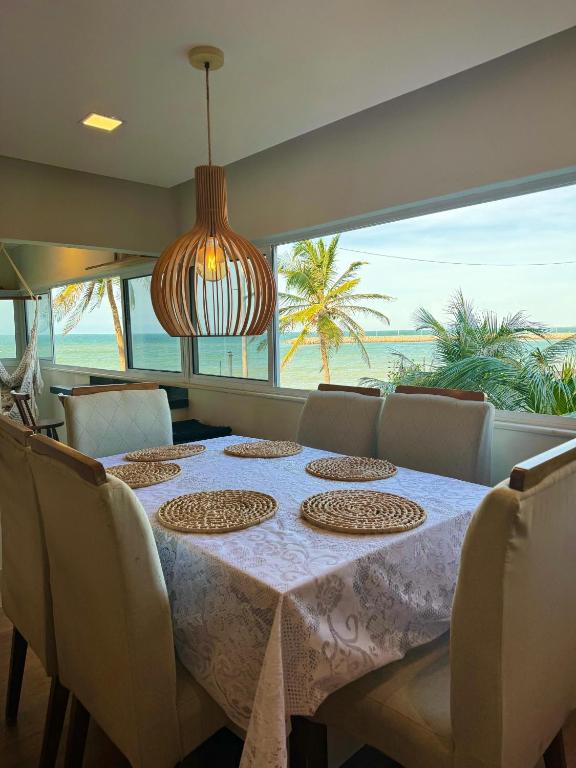 uma sala de jantar com uma mesa e vista para o oceano em Kite house em Caucaia