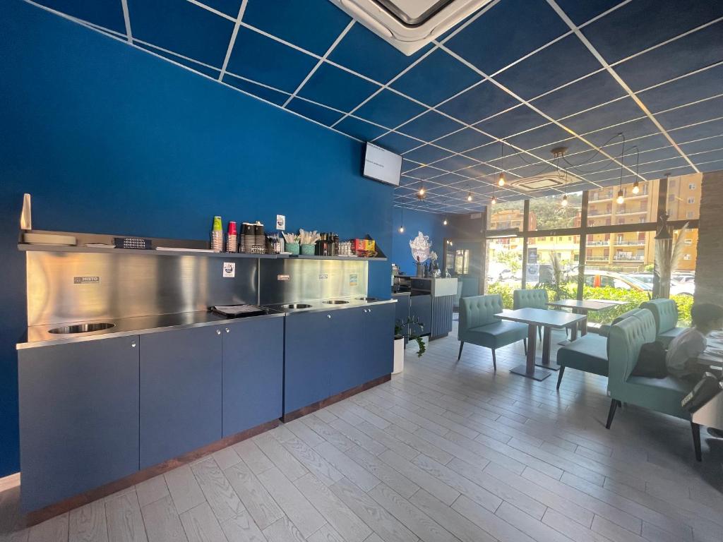 a kitchen with blue walls and a table and chairs at Ne parliamo Stasera in Porto Santo Stefano