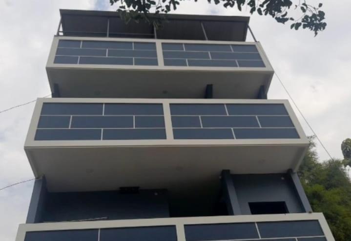 a tall building with blue windows on it at My Homestay SYARIAH in Sarongge