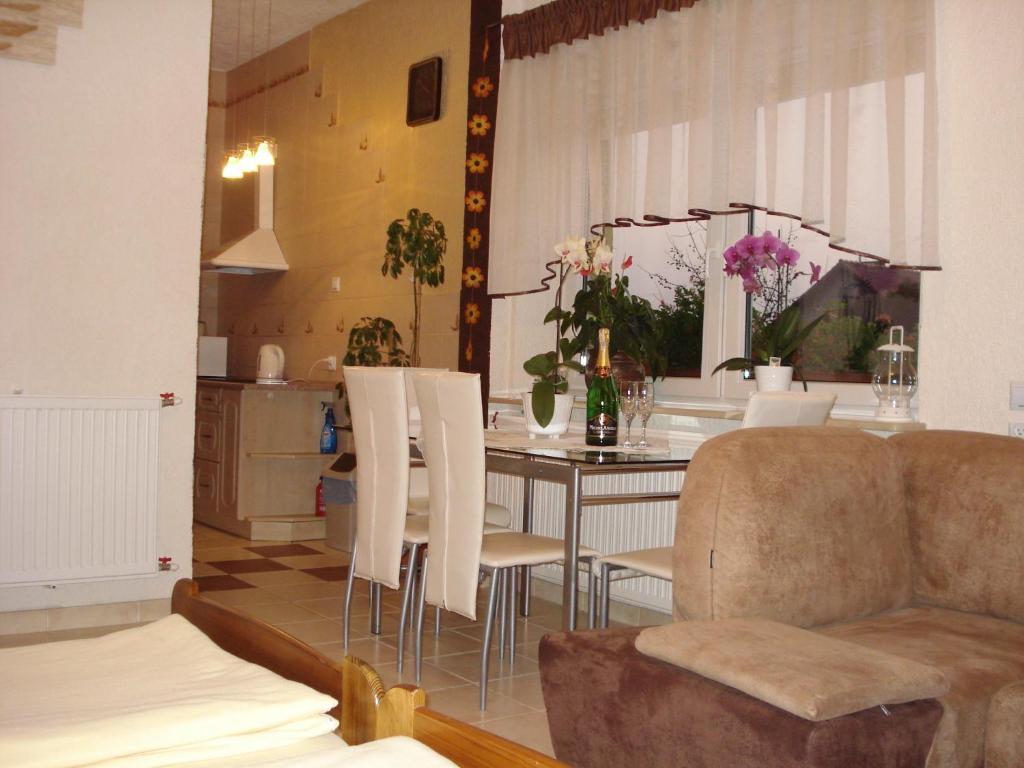 - un salon avec une table et des chaises blanches dans l'établissement Pokoje Gościnne IRGA Apartamenty, à Starogard Gdański
