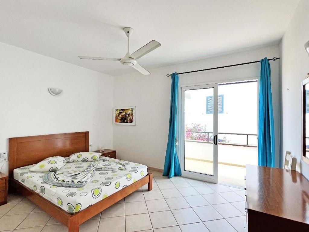 - une chambre avec un lit et une porte coulissante en verre dans l'établissement Sal service leme bedje residence, à Santa Maria
