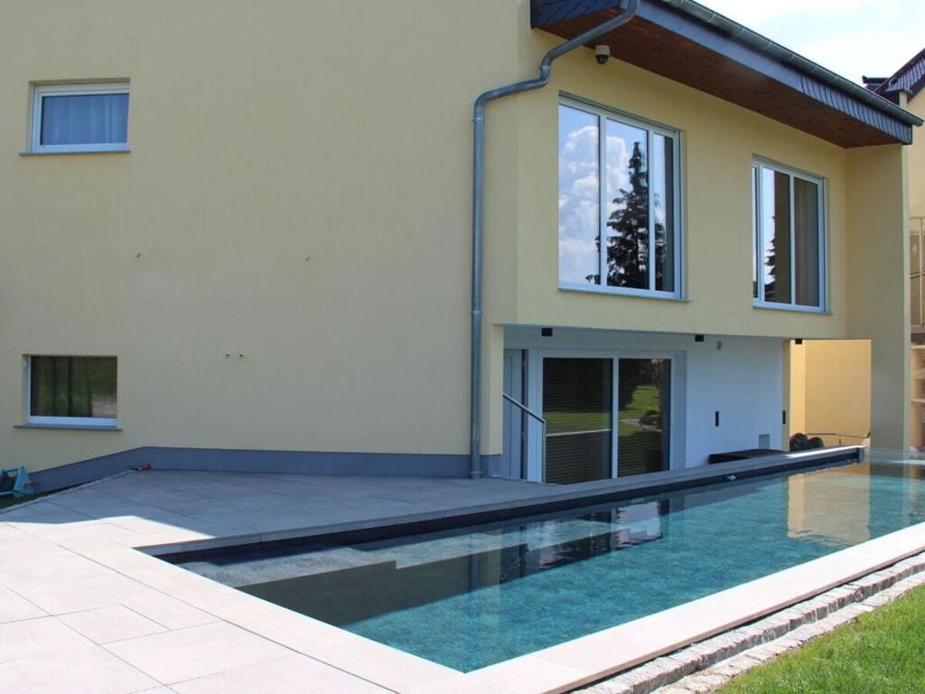 a house with a swimming pool in front of a house at Burk´s Scheune Comfortable holiday residence 