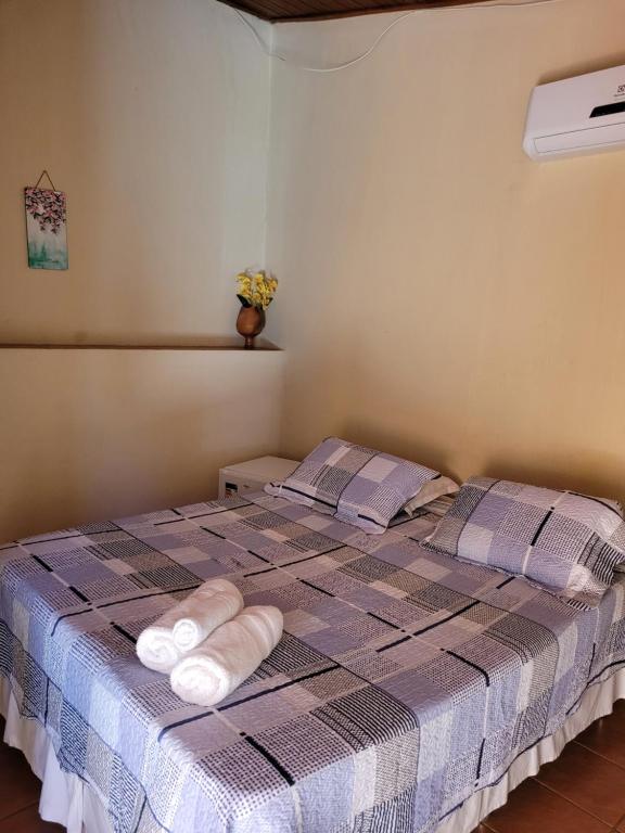 a bedroom with a bed with towels on it at Brisa da Serra Hotel Pousada Pirenopolis in Pirenópolis