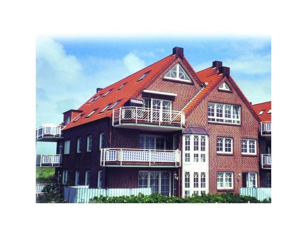 ein großes Backsteinhaus mit orangefarbenem Dach in der Unterkunft Nice holiday home near town centre in Juist