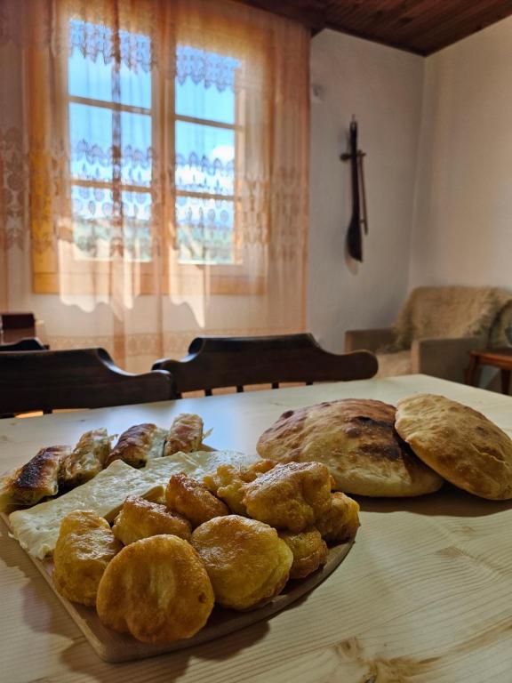 una mesa con una bandeja de pan y bollería. en Traditional House Srna en Mojkovac