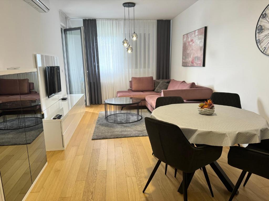 ein Wohnzimmer mit einem Tisch und einem Sofa in der Unterkunft Apartman Eva in Zagreb