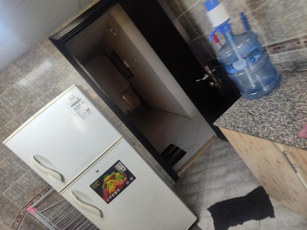 - une cuisine avec un réfrigérateur et une photo dans l'établissement Affordable Comfort: Cozy Room with Dedicated Bath & Twin Beds, à Charjah