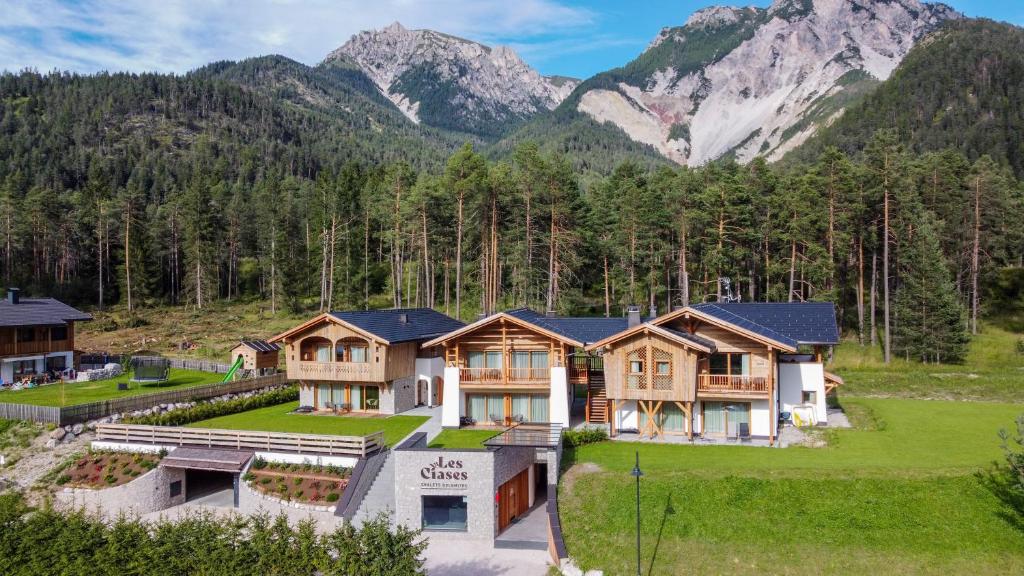 an aerial view of a house with mountains in the background at Les Ciases Chalets Dolomites in San Vigilio Di Marebbe