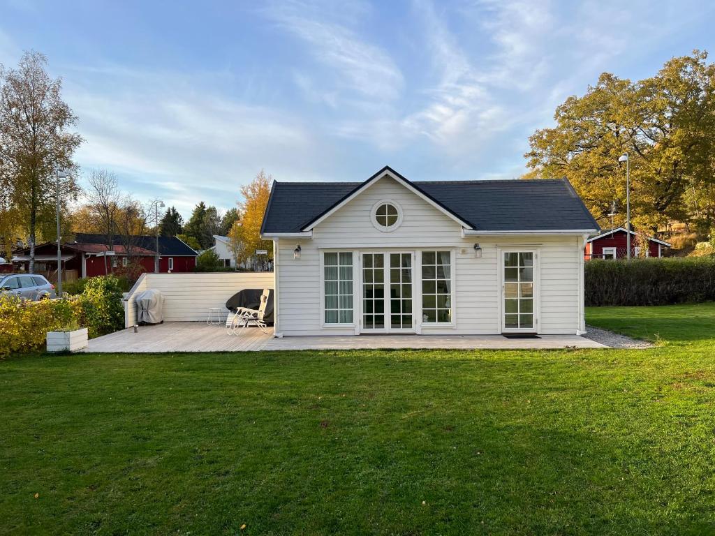 uma casa branca com um pátio e um quintal em White little house on the countryside, close to Stockholm em Vidja