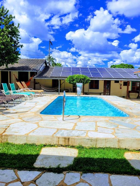 a house with a swimming pool with solar panels at Brisa da Serra Hotel Pousada Pirenopolis in Pirenópolis