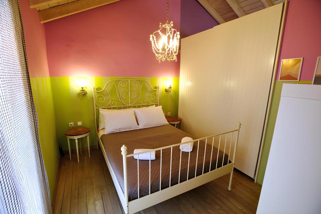 een kleine kamer met een bed en een kroonluchter bij "Wonderland" Nest Nafplio in Nafplio
