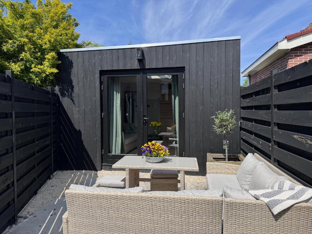 une cour avec une table, des chaises et une clôture noire dans l'établissement Modern guest house., à Bergen