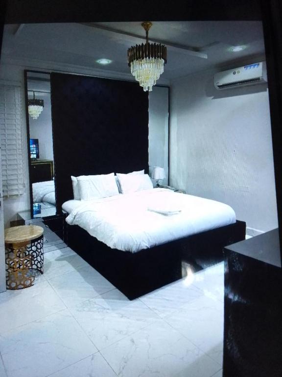1 dormitorio con 1 cama grande y cabecero negro en Koko HOMES LEKKI PHASE 1 en Lagos