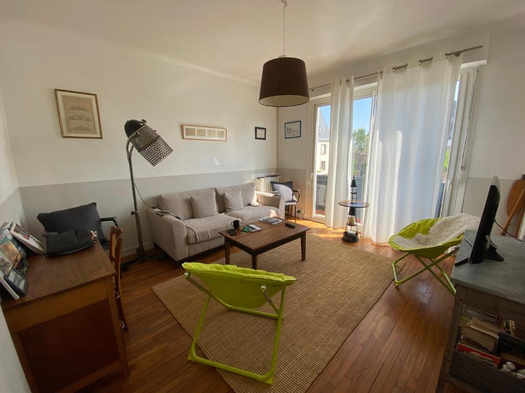 sala de estar con sofá y mesa en RÉF 344 - LARMOR-PLAGE Appartement centre bourg avec balcon plages et commodités à pied, en Larmor-Plage