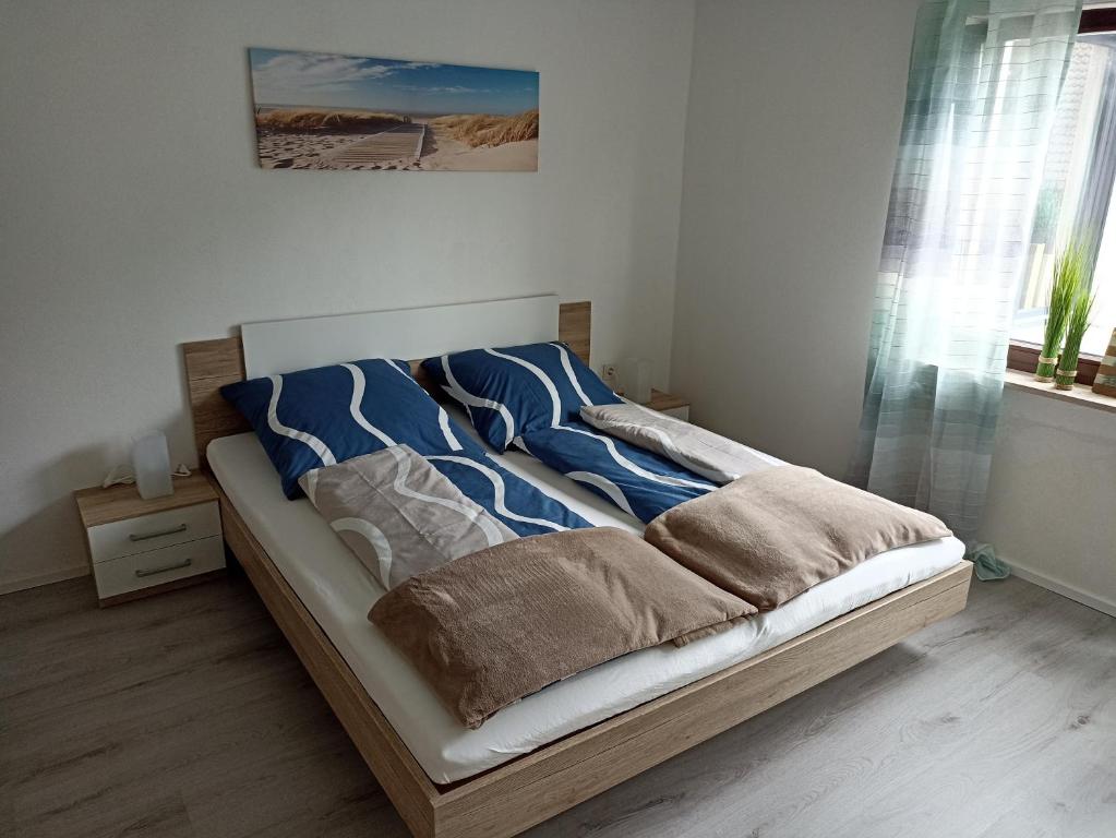 a bed with blue and white blankets and pillows on it at Ferienwohnung Erftalblick in Hardheim