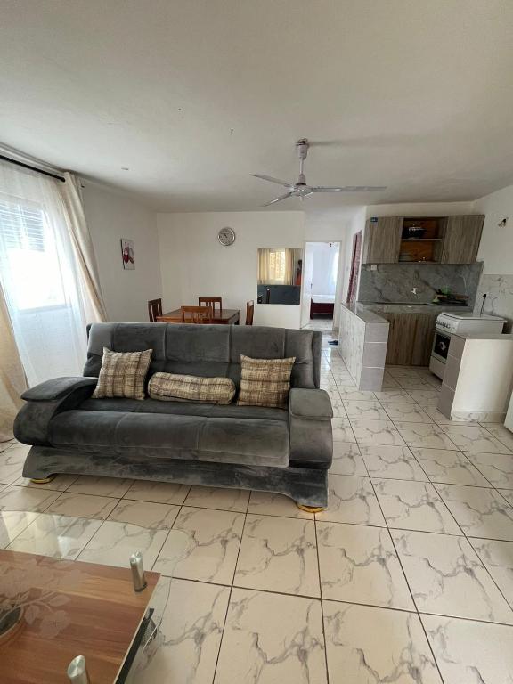 a living room with a couch and a kitchen at Ariosa Apartments in Mtwapa