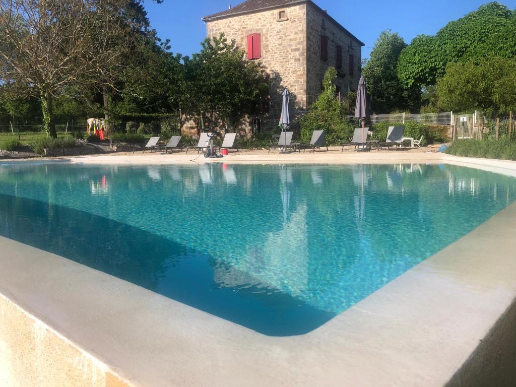 une grande piscine d'eau bleue dans l'établissement Gîtes des Ecuries de Saint Maurice, à Lacapelle-Marival