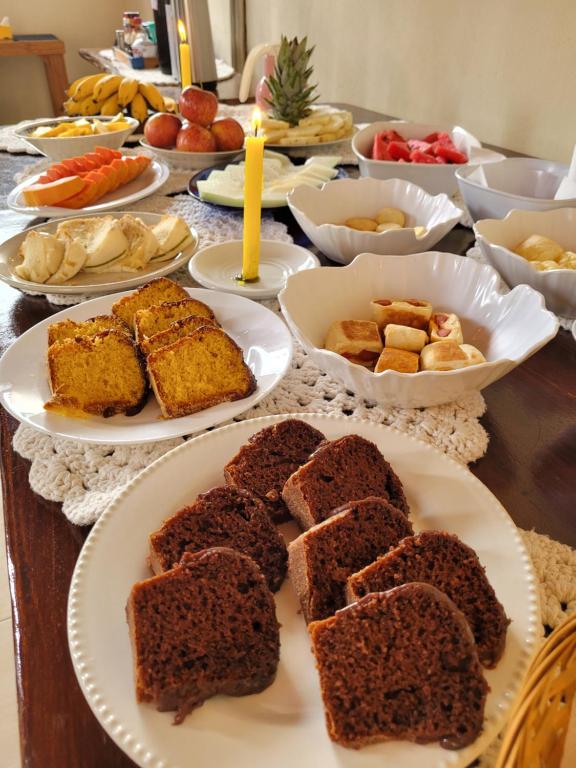 a table topped with plates of cakes and other foods at Brisa da Serra Hotel Pousada Pirenopolis in Pirenópolis