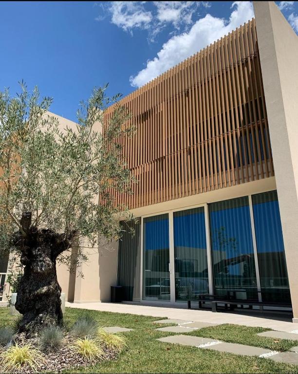 a building with a tree in front of it at Palase GC 141 in Palasë