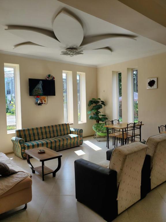 un soggiorno con divani e ventilatore a soffitto di MAKA Hotel a Ureki
