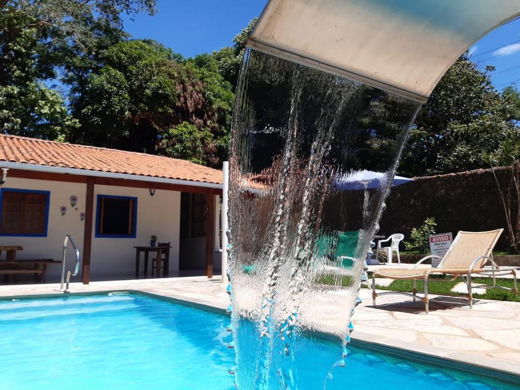 a water fountain in front of a swimming pool at Brisa da Serra Hotel Pousada Pirenopolis in Pirenópolis