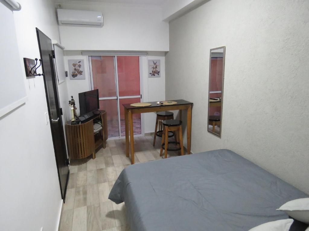 een slaapkamer met een bed, een tafel en een bureau bij Espectacular Departamento en Vicente Lopez ,Avenida San Martín 2248 in Vicente López