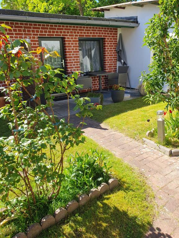 a garden with a brick house with a brick yard at FeWo Inselzeit in Ueckeritz