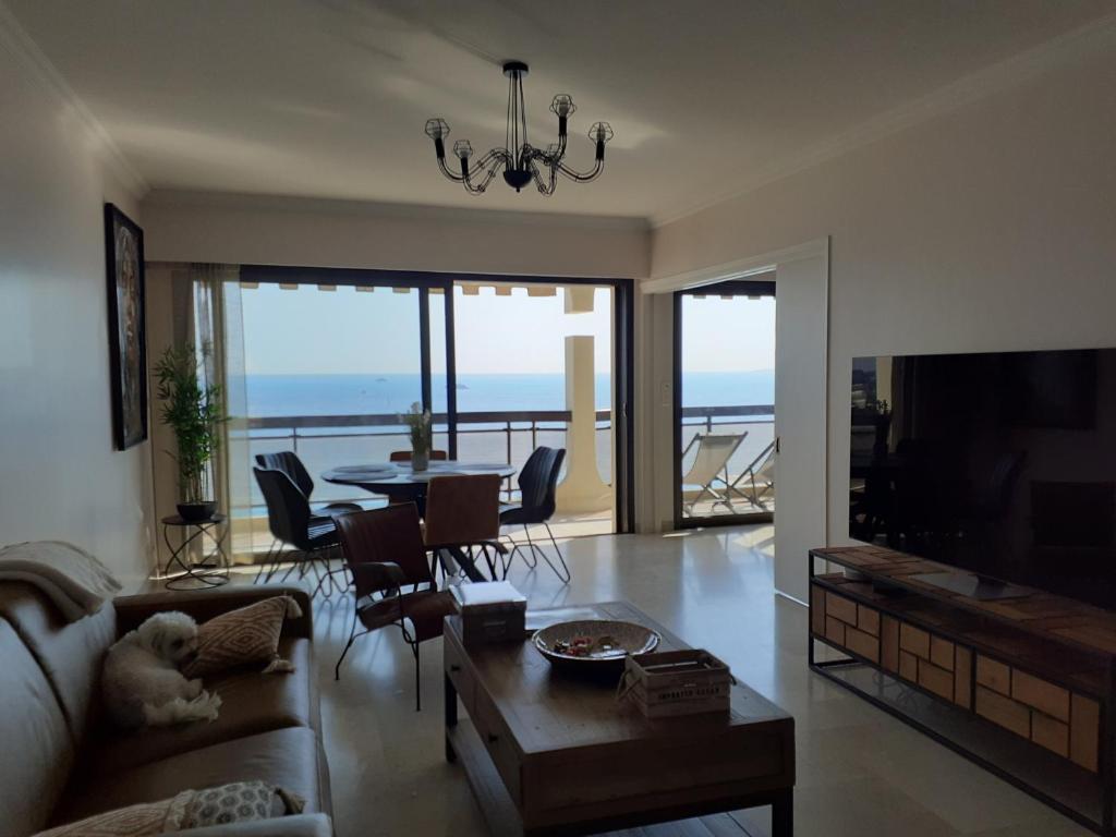 un salon avec un canapé et une table dans l'établissement Bel appartement, sublime vue mer, 2 terrasses, à Antibes