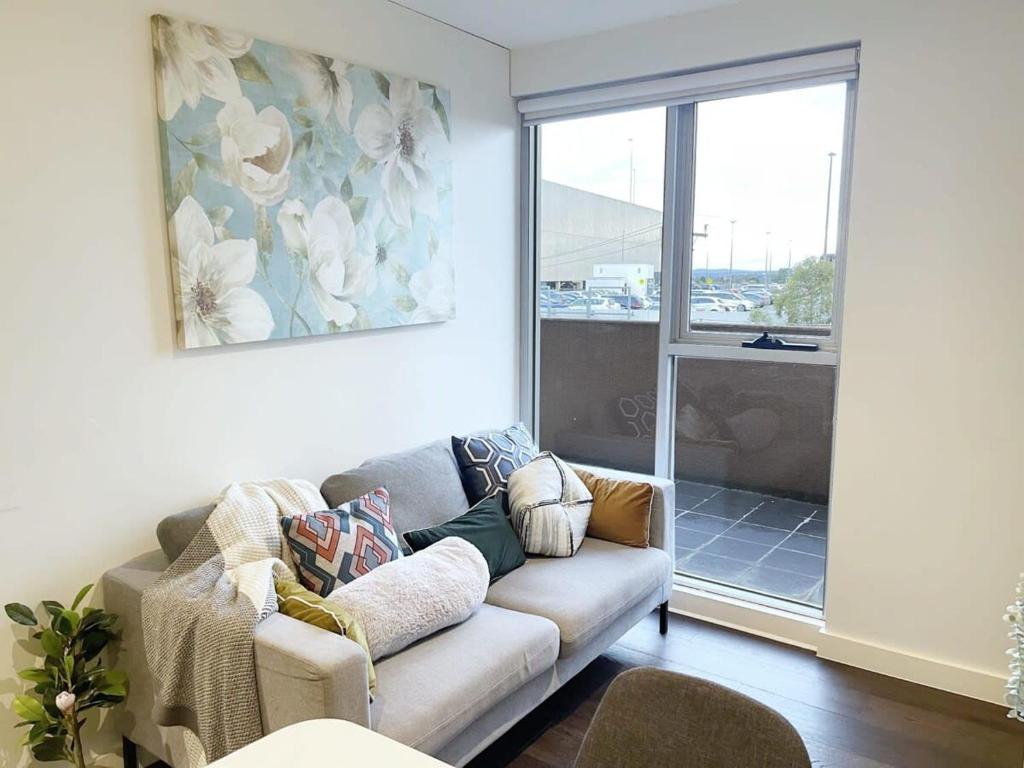 a living room with a couch and a window at Chic Short Stay Retreat at Doncaster in Doncaster