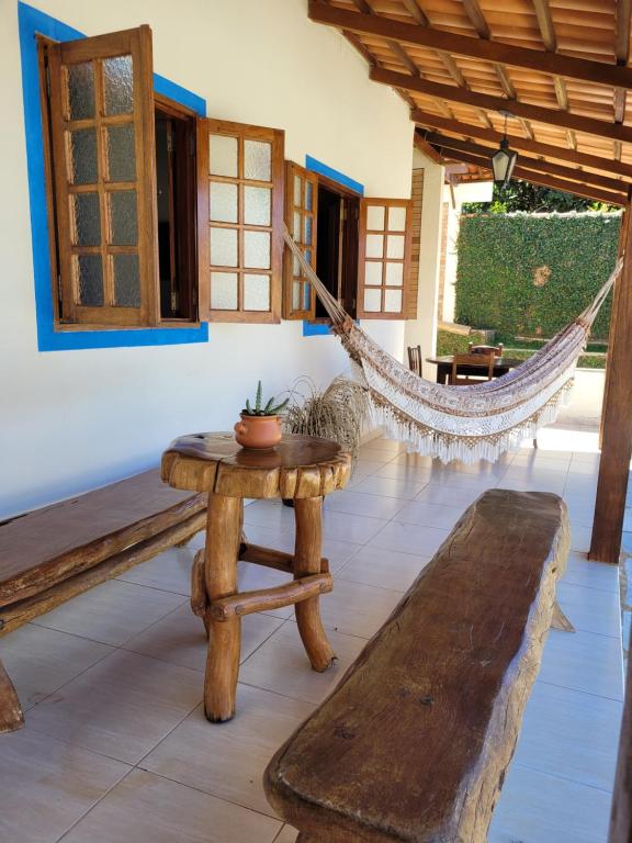 a room with a hammock and a table and a bench at Brisa da Serra Hotel Pousada Pirenopolis in Pirenópolis