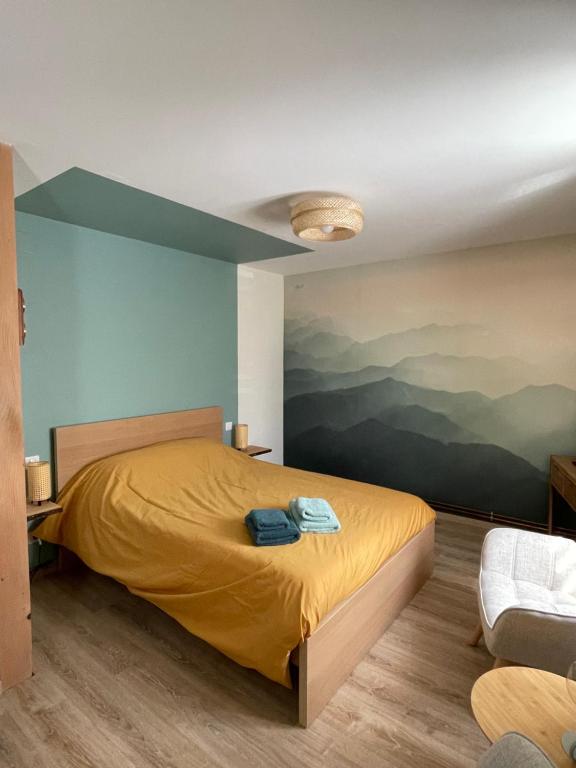 ein Schlafzimmer mit einem gelben Bett und einem Gemälde an der Wand in der Unterkunft Rêverie du Val in Triembach-au-Val