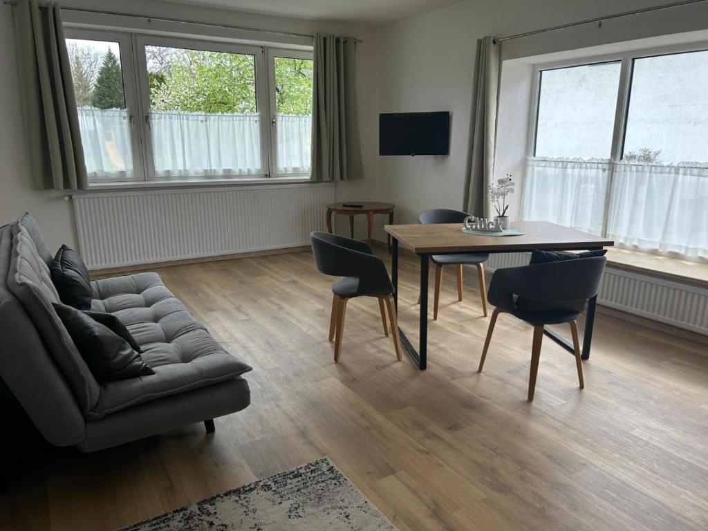 een woonkamer met een tafel en stoelen en een bank bij Apartment Attergautraum 1 in Sankt Georgen im Attergau