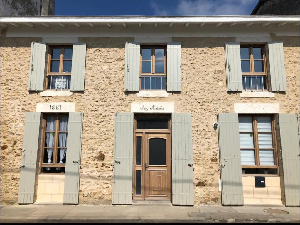 - un bâtiment en briques avec des fenêtres et une porte en bois dans l'établissement Maison de ville à deux pas de la dune du Pilat, à Salles