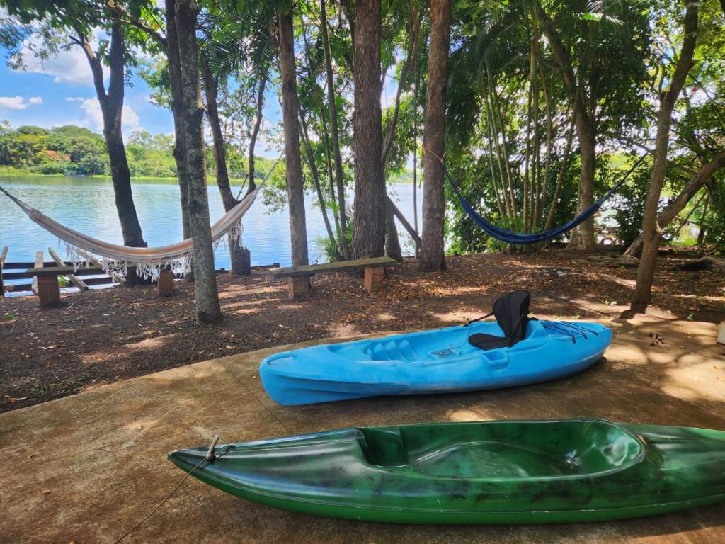 a hammock and a kayak on a table next to a lake at Chácara Pingo de Ouro in Salto Grande