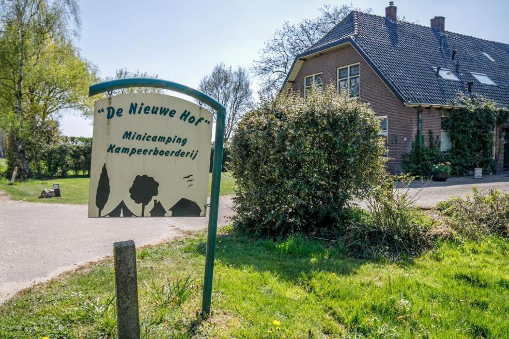 a sign in the grass in front of a house at Camping De Nieuwe Hof in Otterlo
