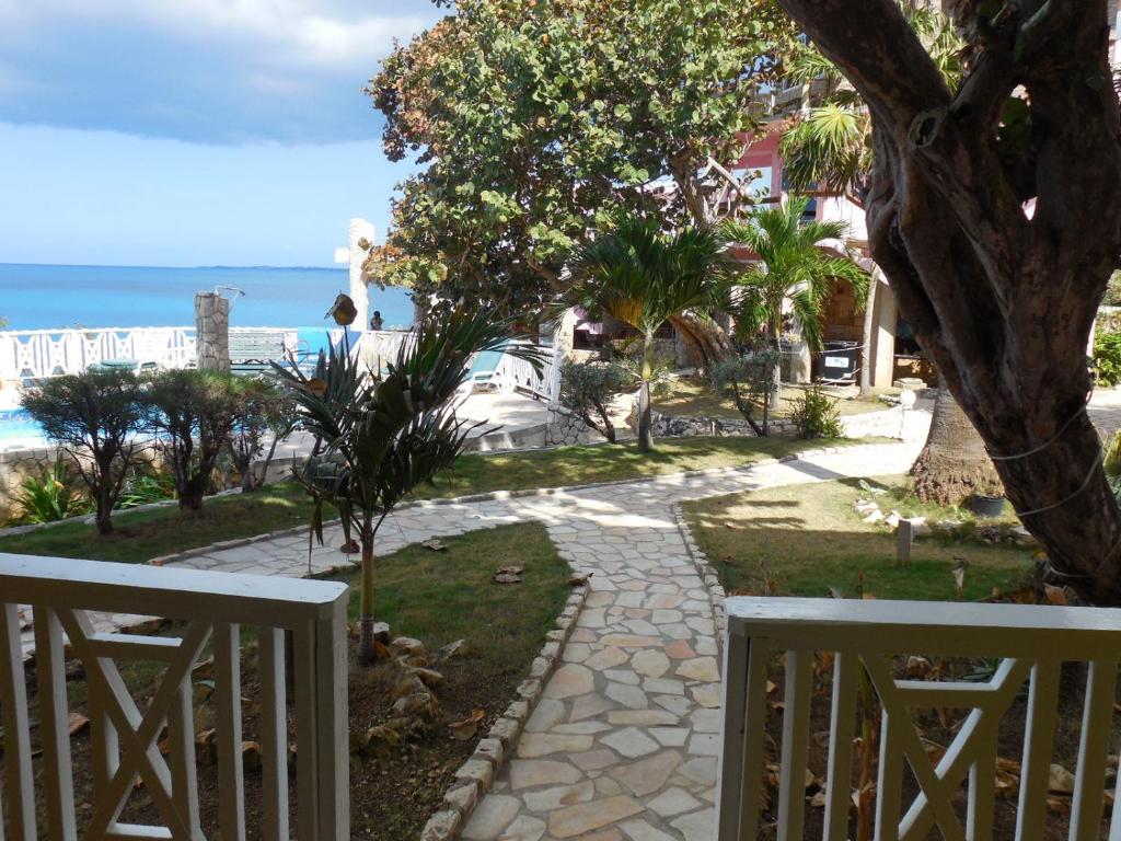 a walkway leading down to a beach with a tree at home sweet home resort in Negril