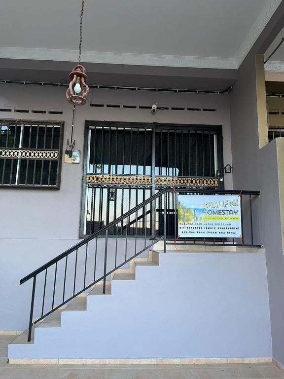 a staircase in a building with a sign on it at KHALiFAH HOMESTAY in Kampong Bugis