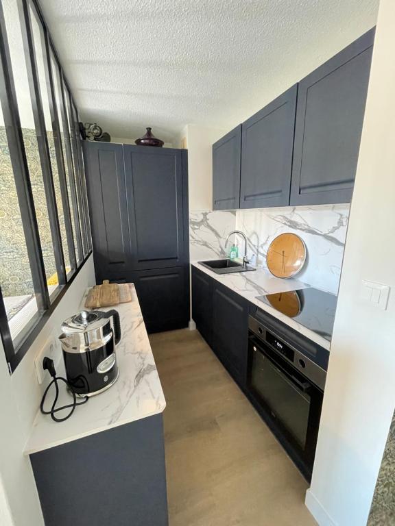 une cuisine avec des armoires bleues et un comptoir dans l'établissement Quiberon plage et ville, à Quiberon