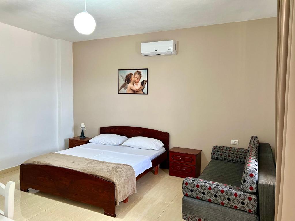 a small bedroom with a bed and a chair at Tomi Apartments in Sarandë