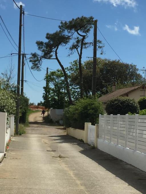 un chemin de terre avec une clôture et un arbre dans l'établissement Maison de pêcheur au pied de la plage avec vélos, à Jard-sur-Mer